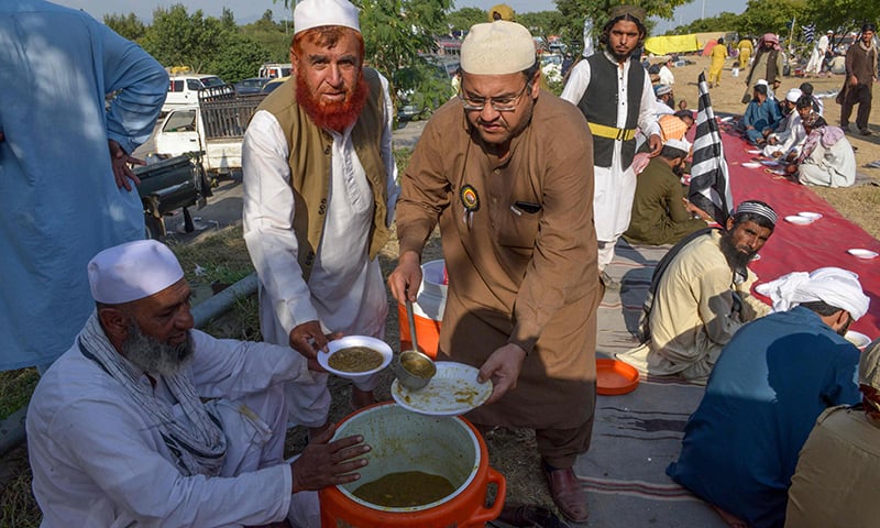 Opposition activists look on as they distribute food during the 'Azadi March' in Islamabad on November 3, 2019.  AFP