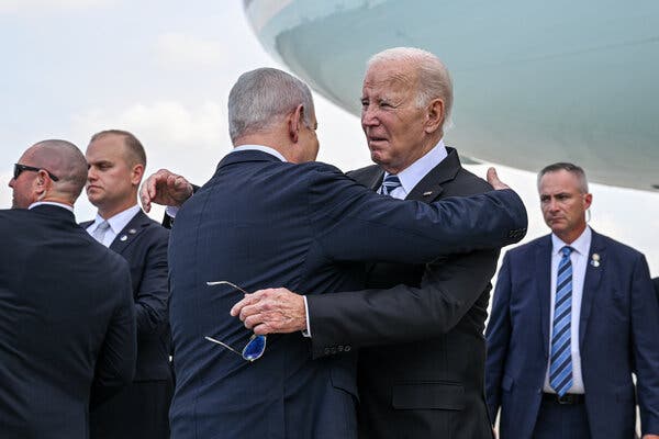 Mr. Biden hugging Prime Minister Benjamin Netanyahu outdoors with security personal nearby.